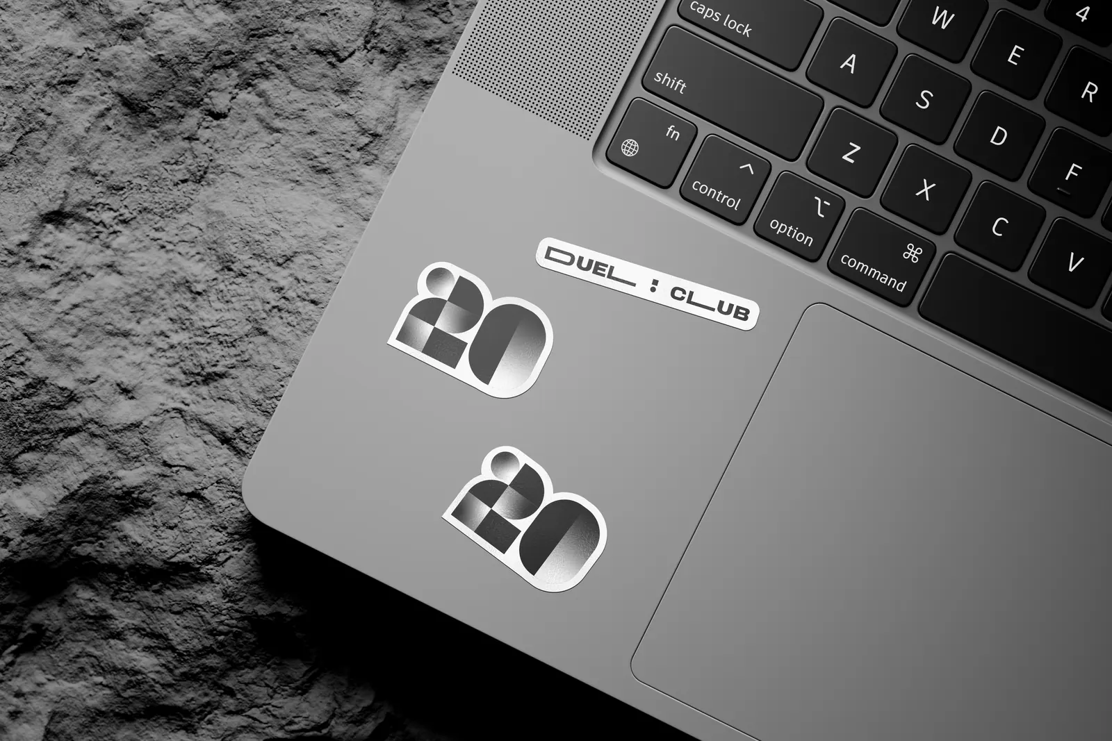 Duel Club stickers on a silver laptop